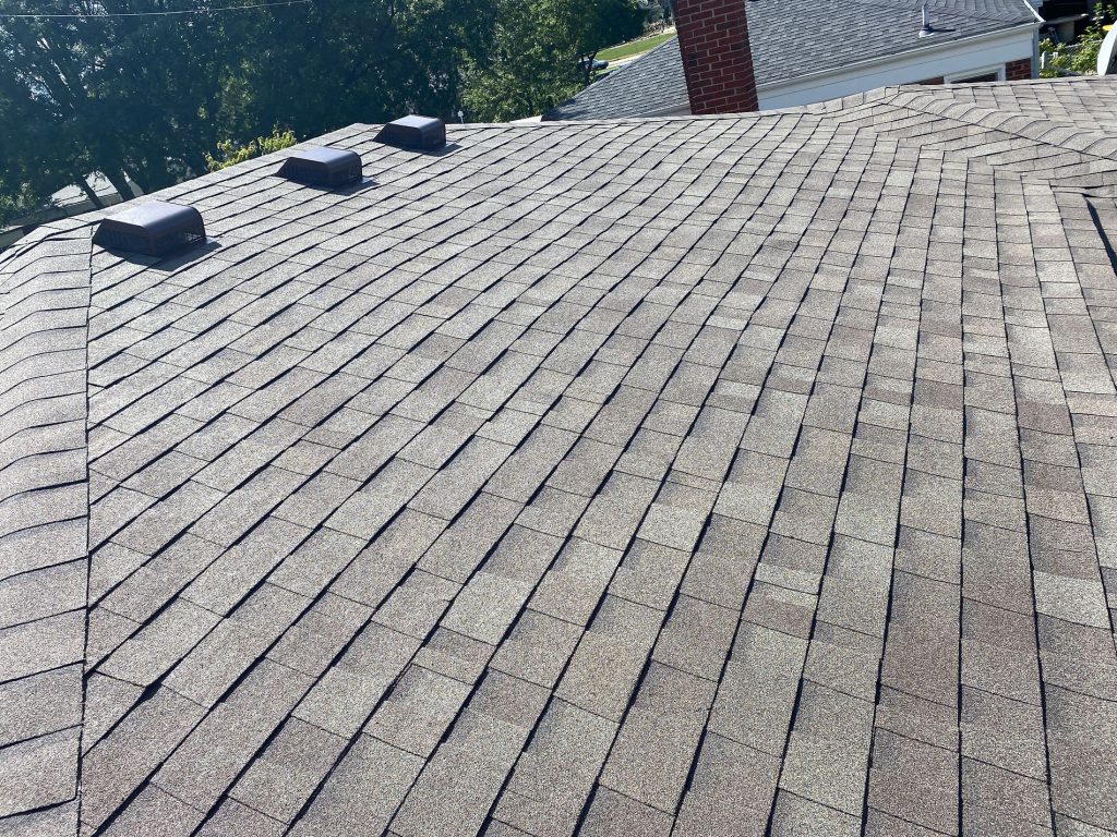 Finished hip roof in St. Clair Shores with brown blended architectural shingles and three dark box vents
