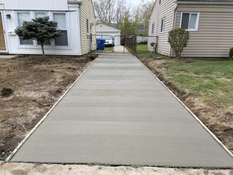 Freshly poured concrete driveway running between two sided homes to a rear gate on Ehlert in Warren, MI