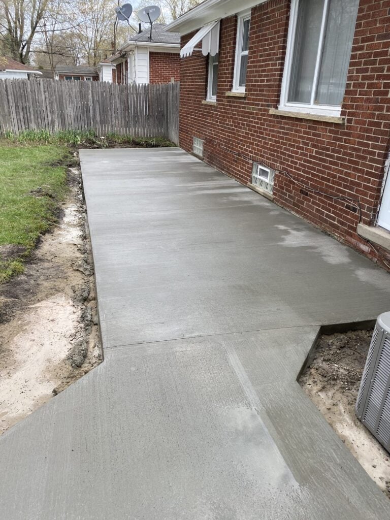 Freshly poured concrete patio and side walk along a red brick home on Edgewood Street in St. Clair Shores, MI