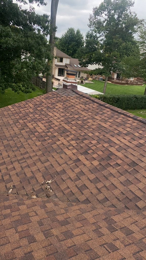 View down a newly shingled brown asphalt roof toward the backyard on Bangor Drive in Sterling Heights, MI