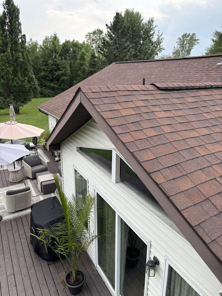 Brown architectural shingle roof over a white sided home and back deck on Lowe Plank Road in New Haven, MI