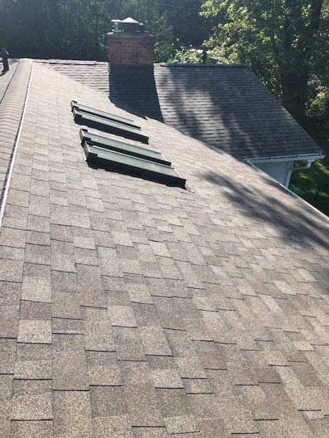 Newly installed shingle roof with three skylights and a brick chimney on Polvadera Street in Commerce Township, MI