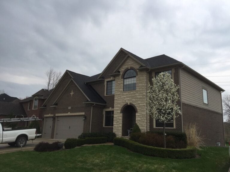 Two-story brick and stone home with a dark shingle roof on Nautical Lane in Harrison Township, MI