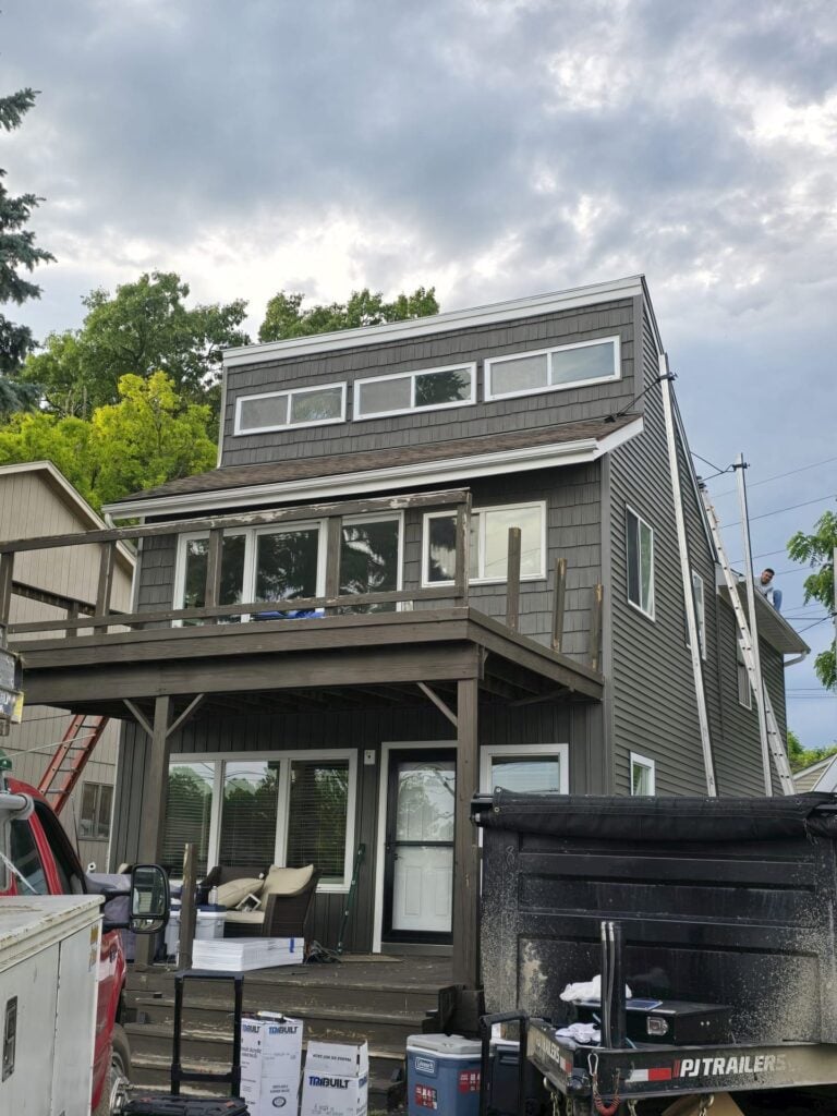 Rear of a modern two-story home with new brown siding and clerestory windows on Andersonville Road in Clarkston, MI