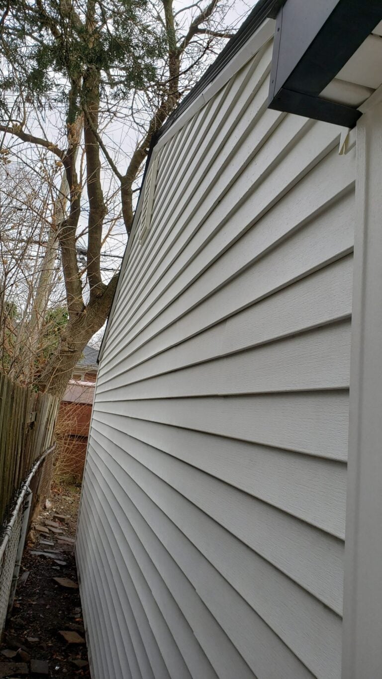Close-up of newly installed beige lap siding along the side wall of a home on Brady in Redford Township, MI