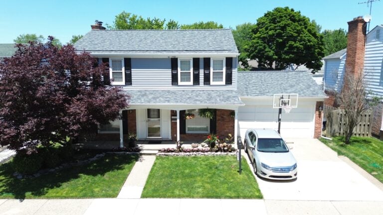 Two-story colonial with new blue-gray siding and black shutters on Danbury Lane in Harper Woods, MI