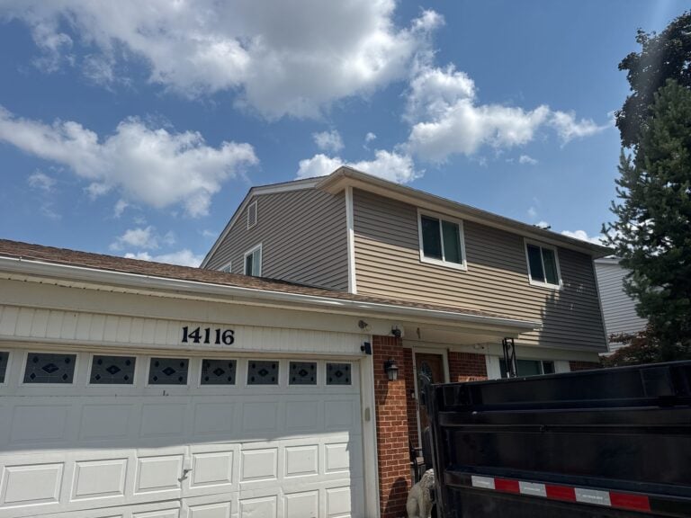 Two-story home with new tan lap siding and trim above a brick first floor on Levan Road in Livonia, MI