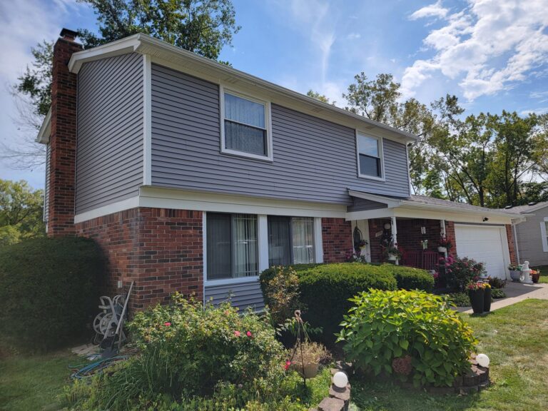 Two-story home with new gray lap siding and white trim over a brick lower level on Morrison Street in Southfield, MI