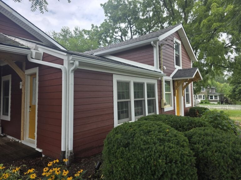 Historic-style home with new red lap siding, white trim and yellow doors on Salem Road in Plymouth, MI