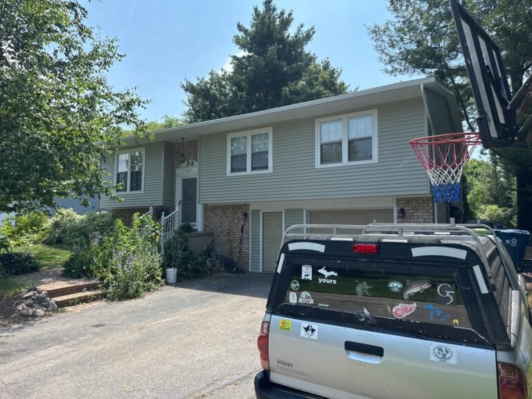 Split-level home with updated sage green siding over brick on Satelite Drive in White Lake, MI