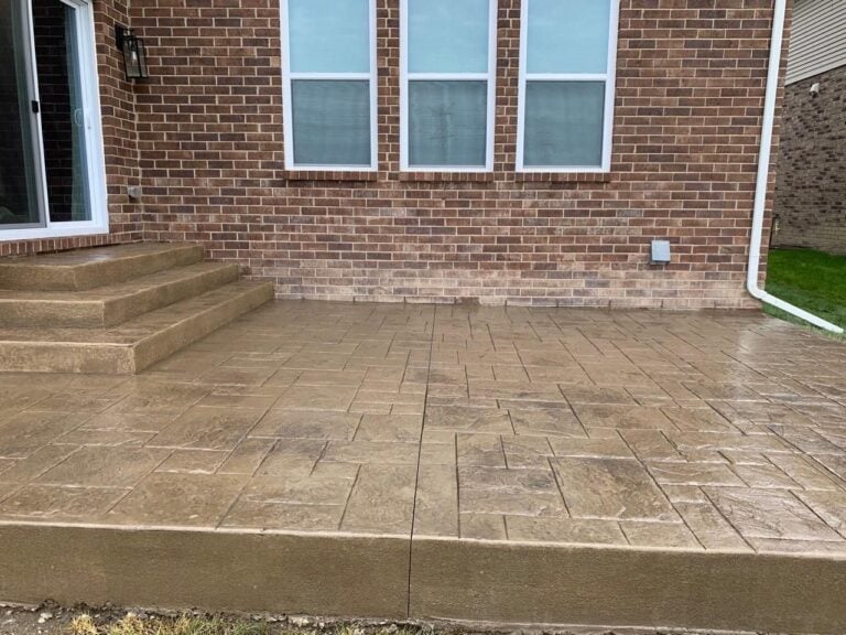 Tan stamped concrete patio with matching steps at the back of a brick home on Steed Drive in Canton, MI